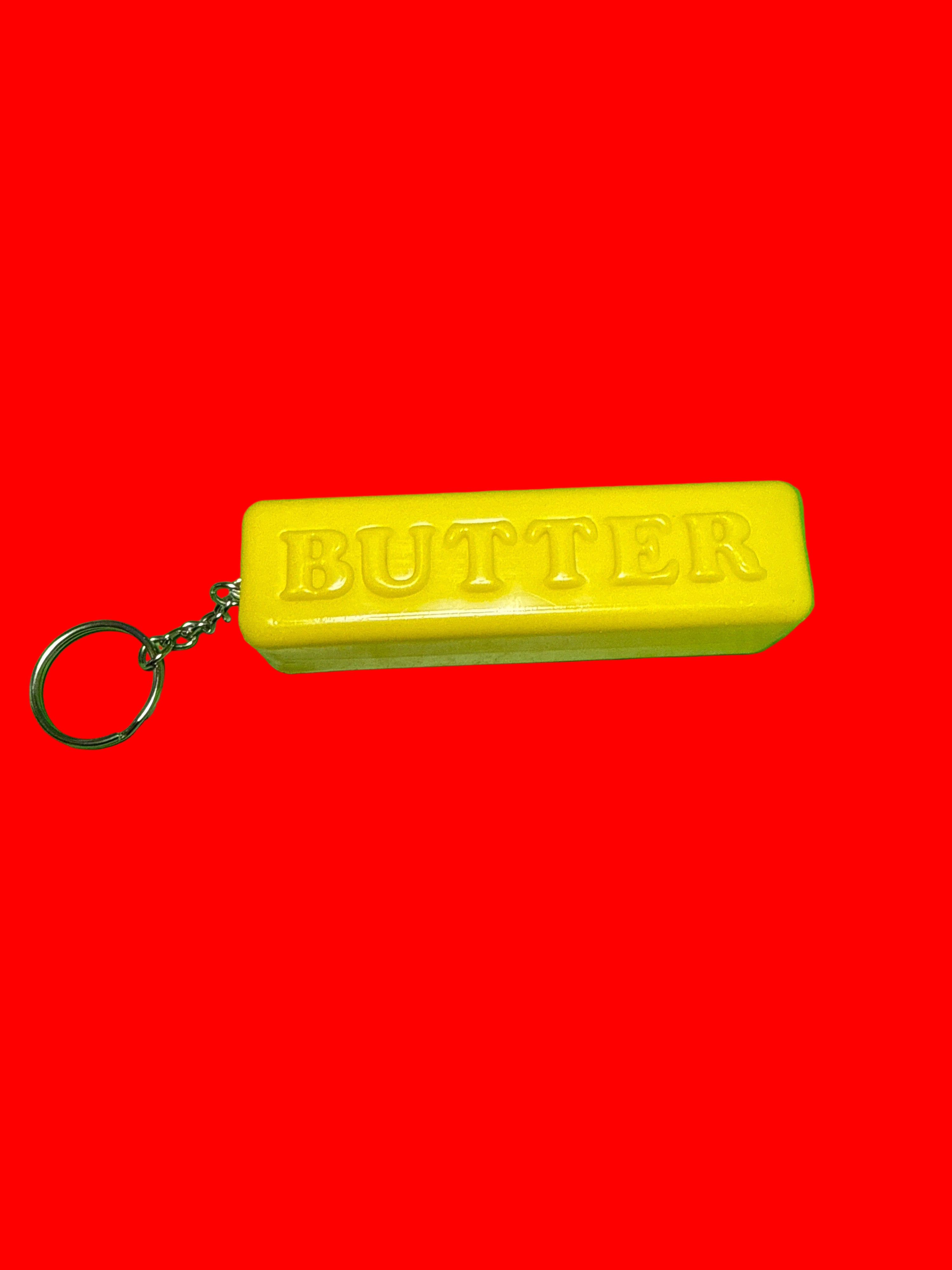 Plastic butter keychain on red background 