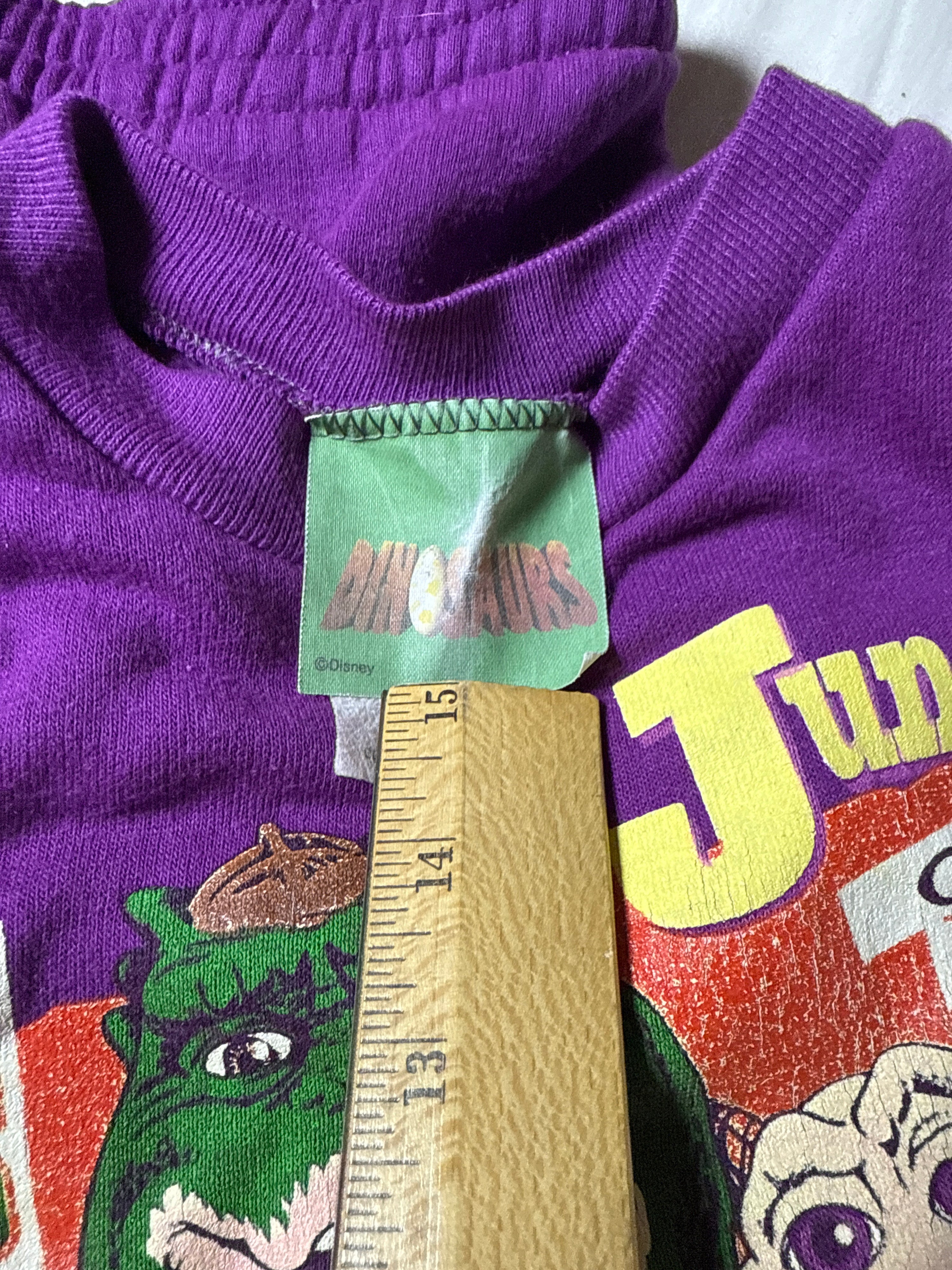 Purple sweater with a brand tag and colorful design on a white background