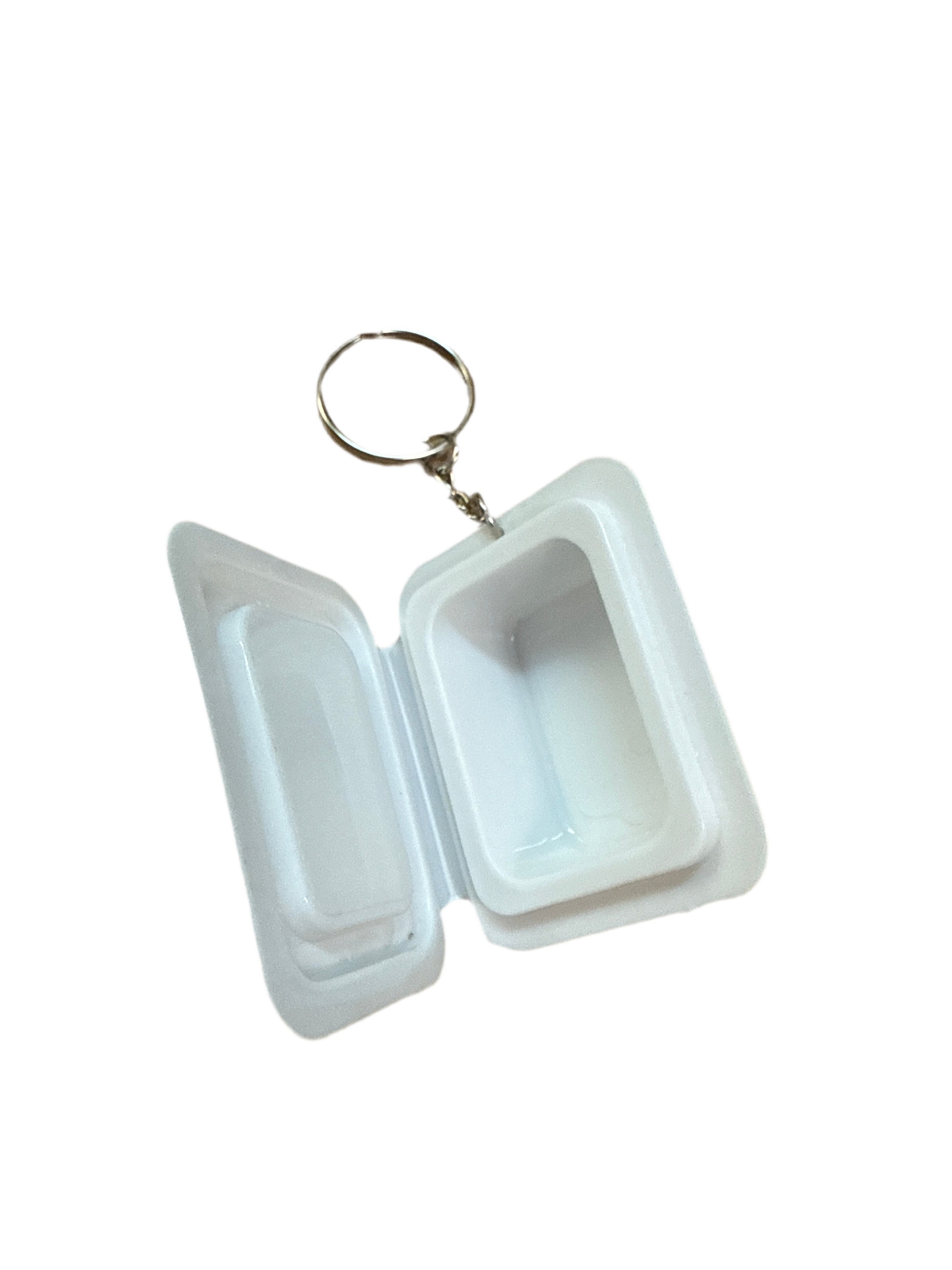 White plastic container with a keychain attached on a white background