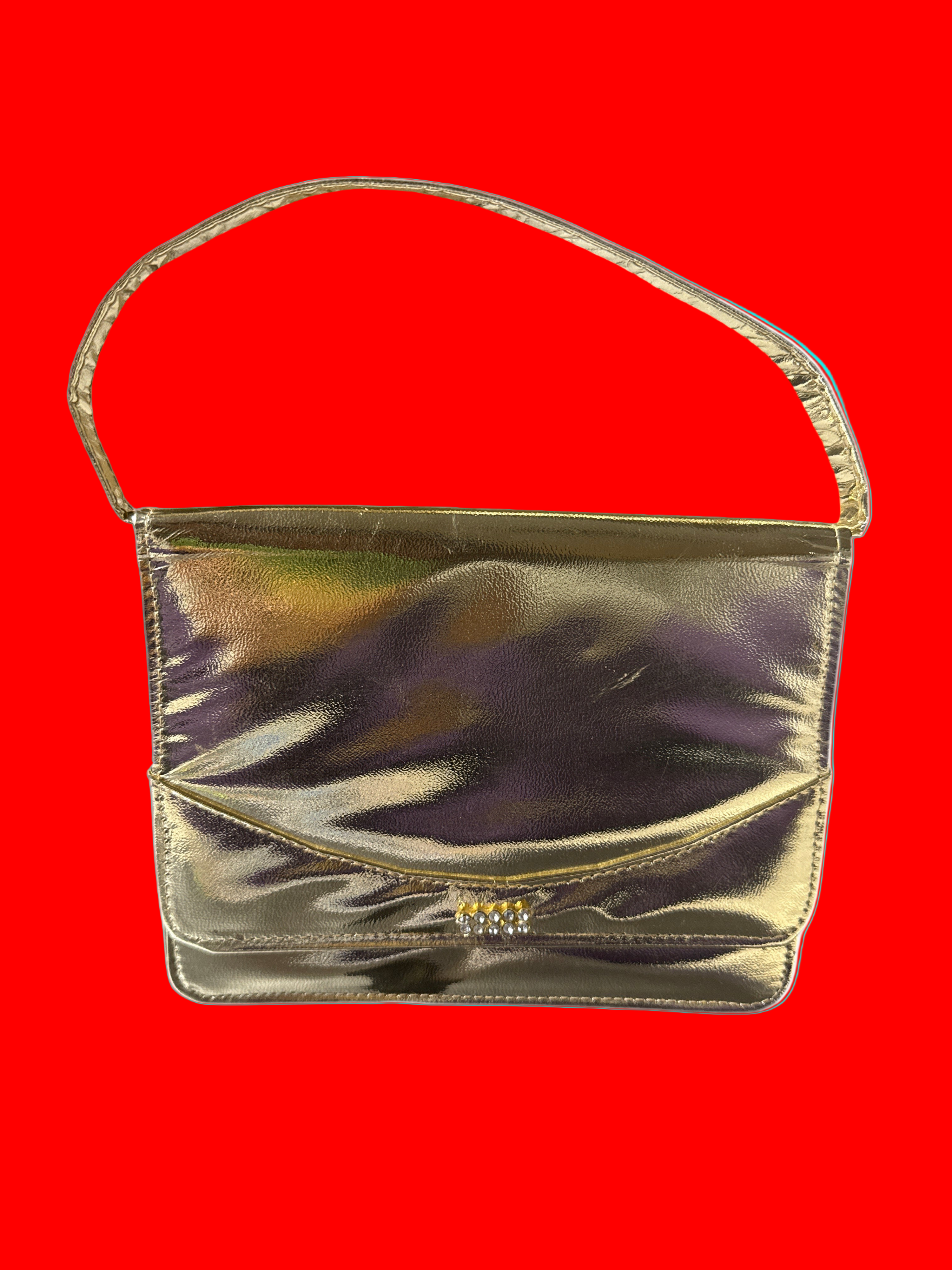 Gold metallic handbag on a red background